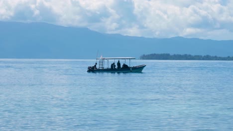 Blick-Auf-Das-Blaue-Meerwasser-Einer-Gruppe-Von-Tauchern,-Touristen-Von-Einem-Tourismus-Liveaboard-Schiff-Auf-Einem-Kleinen-Tauchboot,-Das-über-Einem-Korallenriff-Vor-Einer-Abgelegenen-Tropischen-Insel-Taucht