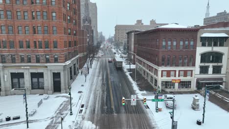 Toma-Aérea-De-Establecimiento-De-Una-Intersección-De-La-Ciudad-Mientras-Cae-Nieve