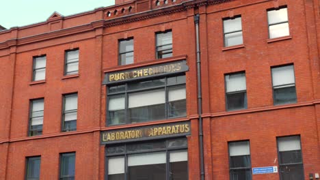 Toma-Cinematográfica-Giratoria-De-La-Arquitectura-De-Un-Edificio-De-Ladrillo-En-Dublín,-Irlanda,-Durante-Un-Día-Nublado.