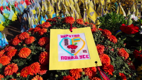 Khreshchatyk-street-with-red-flowers-and-Ukrainian-memorial-flags-with-names-of-fallen-soldiers-in-Kyiv-Ukraine,-honor-for-the-soldiers-who-died-during-the-Russia-Ukraine-war,-honoring-remembering,-4K