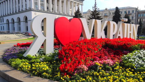 Me-Encanta-El-Letrero-De-Ucrania-En-La-Calle-Principal-De-Khreshchatyk-Con-Flores-En-La-Capital-De-La-Ciudad-De-Kiev,-Ucrania,-Hermoso-Centro-De-La-Ciudad-Con-Plantas-Y-Edificios,-Toma-De-4k