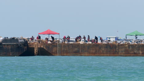 Construction-workers-working-on-the-renovation-and-fixing-the-damage-of-a-boardwalk-at-the-beachfront-of-Pattaya,-in-Chonburi,-Thailand