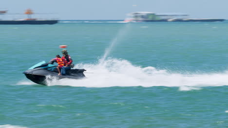 Turista-Divirtiéndose-Practicando-Diferentes-Deportes-Acuáticos-Mientras-Viaja-En-Un-Bote-Banana,-Lancha-Rápida-Y-Motos-Acuáticas-En-La-Playa-De-Pattaya,-En-La-Provincia-De-Chonburi-En-Tailandia