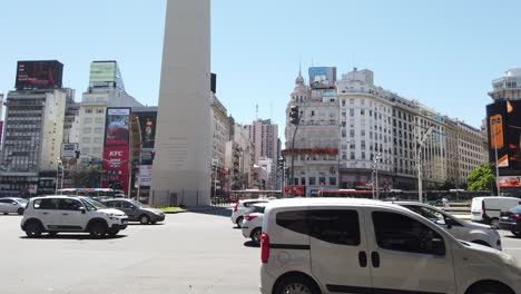 El-Tráfico-De-Automóviles-Pasa-Por-La-Avenida-9-De-Julio-Y-El-Obelisco-Del-Centro-De-La-Ciudad,-Un-Punto-De-Referencia-Nacional-Y-De-Negocios.