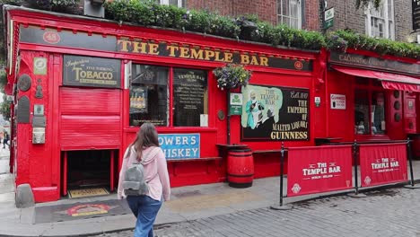 Una-Mujer-Camina-Hacia-El-Temple-Bar,-Famoso-Pub-En-El-Centro-De-La-Ciudad-De-Dublín.