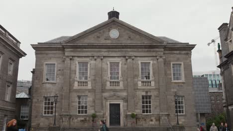 Students-walking-in-front-of-old-building-Trinity-College-on-a-cloudy-day