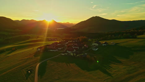 Hermosas-Tomas-Con-Rayos-De-Sol-En-Un-Campo-Verde-Con-Montañas-Y-Algunas-Casas