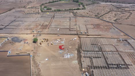 Aerial-drone-view-moving-towards-side-where-many-large-bundles-of-wires-are-visible-and-a-large-solar-farm-is-also-visible