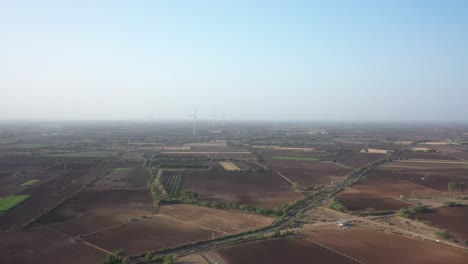 Luftdrohnenansicht-Des-Sich-Vorwärts-Bewegenden-Drohnen-Camaro-Mit-Vielen-Windmühlen-Und-Großen-Feldern-Und-Bäumen-In-Der-Umgebung