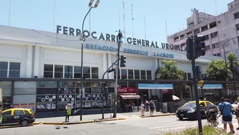 Establishing-Shot-of-Urquiza-Railway-Station-Streets-People-and-Traffic-Skyline-at-Federico-Lacroze-Train,-Chacarita-Neighborhood,-Argentine-Public-Transportation