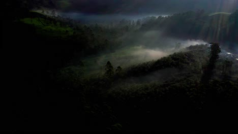 Aerial-drone-view-camera-moving-to-the-side-where-the-hills-are-glowing-with-greenery-as-the-sun-rays-fall