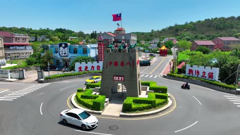 Luftaufnahme-Eines-Touristen-Auf-Dem-Historischen-Turm-Am-Kreisverkehr-Auf-Der-Insel-Kinmen-An-Einem-Sonnigen-Tag---Historisches-Soldatendenkmal-Mit-Wehender-Flagge