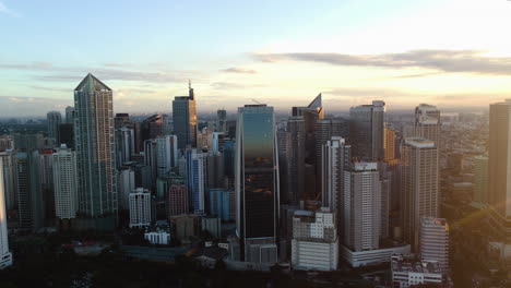 Drone-flying-in-front-of-the-Makati-skyline,-vivid-evening-in-Manila,-Philippines