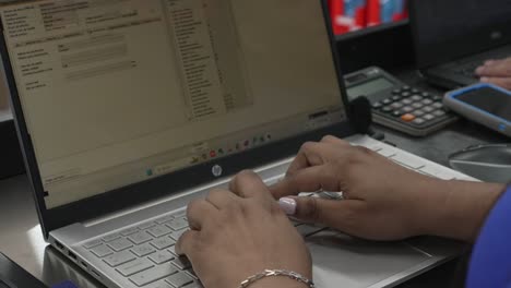 Latin-woman-working-typing-with-her-hands-on-a-computer-on-her-office-desk