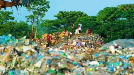 Niños-Recolectores-De-Trapos-Carroñeros-Buscando-Comida-Alrededor-De-Un-Montón-De-Basura-Sucia-En-Un-Vertedero-Mientras-La-Topadora-Abandona-El-Sitio