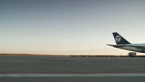 Frachtflugzeuge-Auf-Dem-Rollfeld-Bei-Sonnenaufgang-Mit-Klarem-Himmel-Und-Flughafenfahrzeugen-Im-Hintergrund