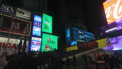 POV-shot-driving-past-people-at-Times-square,-nighttime-in-Manhattan,-New-York