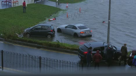 Grupo-De-Personas-Ayudándose-Mutuamente-Para-Rescatar-Autos-Durante-La-Tormenta-Fergus