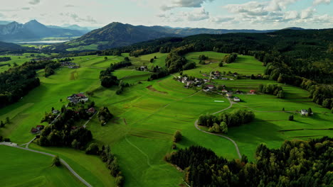 Beautiful-aerial-shot-of-the-green-hilly-countryside-with-trees-and-a-cloudy-sky