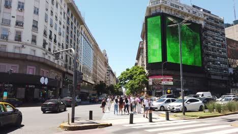 People-Cross,-Car-Traffic-in-9-de-Julio-Avenue-Business-Downtown-Center,-Summer-and-Traditional-Buildings,-Skyline,-Latin-American-Capital