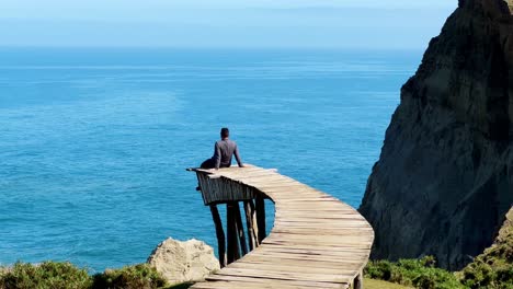 Eine-Person-Entspannt-Sich,-Sitzt-Am-Muelle-De-Las-Almas-Dock,-Meer,-Patagonien,-Berglandschaft