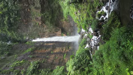 Los-Turistas-Se-Reúnen-En-Un-Terreno-Accidentado-Debajo-De-La-Cascada-Kapas-Biru-En-Java