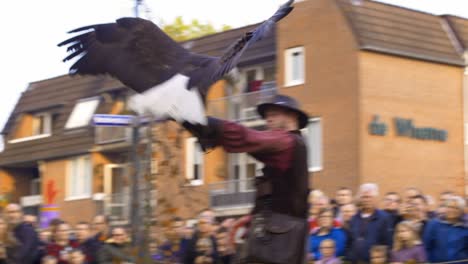 American-eagle-flies-from-falconer-hand-towards-another-man-while-a-crowd-is-watching