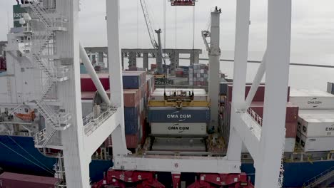 Panoramic-aerial-of-heavy-loader-crane-dropping-container-on-tanker-ship