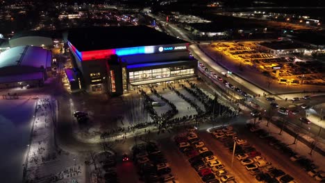 Luftaufnahmen-Zirkulieren-Um-Den-Eingang-Der-Saab-Arena-In-Der-Stadt-Linköping-–-Menschen-Stehen-Bei-Schneereichen-Winterbedingungen-Schlange