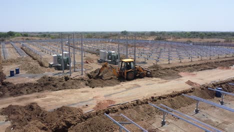 Vista-Aérea-De-Drones-Cámara-De-Drones-Moviéndose-Hacia-Señor-Donde-El-Gran-Jcb-Está-Creciendo-Y-Suministrando-Cables