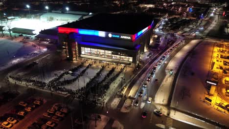 Aerial-retreat---Saab-Arena-crowd-queueing-and-entering-sports-stadium-in-Linköping-City---Drone-pull-away