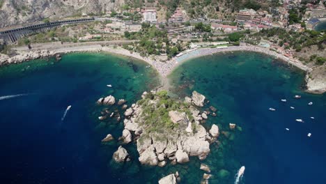 Toma-Aérea-Superior-Sobre-La-Isla-Isola-Bella,-Ubicada-Cerca-De-Taormina,-Cerca-De-La-Costa.