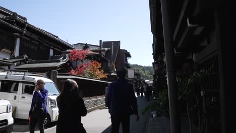 Daytime-capture-of-people-leisurely-walking-along-Sanmachi-Suji,-comprising-three-charming-streets-that-together-form-Hida-Takayama's-renowned-historic-district-in-Japan