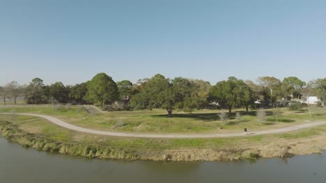 Una-Vista-Aérea-De-Un-Hombre-Adulto-Mayor-Caminando-Con-Un-Bastón-En-Exploración-Verde-En-Un-Soleado-Y-Claro-Día-De-Invierno-En-Clear-Lake,-Houston,-Texas.