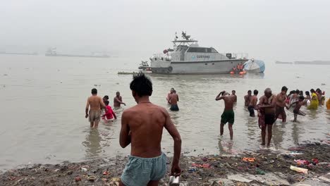 Plano-Amplio-De-Hindúes-Bañándose-En-Babu-Ghat-Para-La-Celebración-Del-Festival-Sankranti-Con-Ferries-Al-Fondo-En-Kolkata