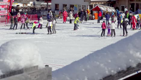 People-at-the-bottom-of-a-ski-slope,-getting-ready-to-get-on-a-ski-lift-in-Innichen---San-Candido,-South-Tyrol,-Italy