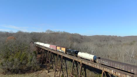 Toma-Aérea-Retrocediendo-De-Un-Tren-De-Carga-Mixto-Cruzando-El-Caballete-Pope-Lick-En-Louisville,-Kentucky,-En-Un-Soleado-Día-De-Invierno