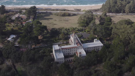 4K-Kino-Drohnenaufnahme-Des-Karmeliterklosters-Mit-Dem-Pacific-Coast-Highway-Und-Dem-Klosterstrand-Im-Hintergrund