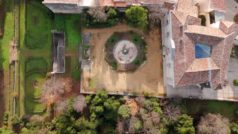 Vista-Aérea-De-Arriba-Hacia-Abajo-Del-Edificio-Del-Castillo-Francés-Y-Del-Pintoresco-Jardín-Forestal-En-Jacou,-Francia