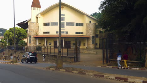 Traffic-in-front-of-the-Temple-du-Cinquantenaire,-sunny-day-in-Yaounde,-Cameroon