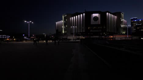 Imágenes-Nocturnas-Del-Palacio-Nacional-De-Cultura---Centro-De-Congresos-De-Sofía,-Con-Gente-Caminando