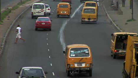 Hombre-Cruzando-La-Carretera-En-Lagos,-Nigeria