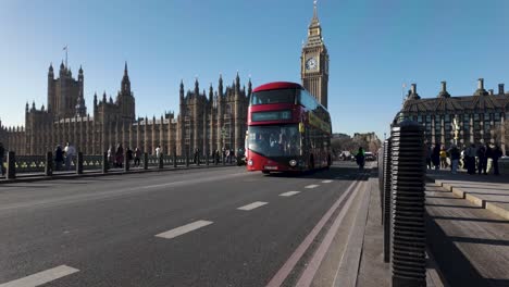 Schwarze-Taxis-Und-Roter-Doppeldeckerbus-Fahren-An-Einem-Sonnigen-Januartag-über-Die-Westminster-Bridge-Mit-Big-Ben-Im-Hintergrund