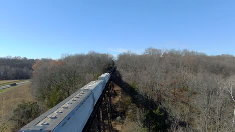 Aerial-Shot-Orbiting-Over-a-Mixed-Freight-Train-Crossing-the-Pope-Lick-Trestle-in-Louisville,-Kentucky-on-a-Sunny-Winter-Day