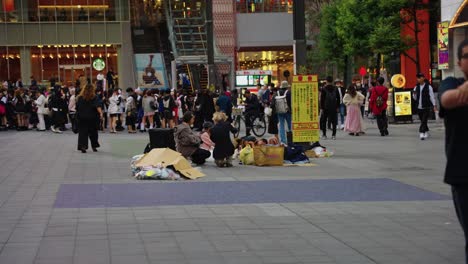 Slow-motion-pan-of-urban-center-of-Shinjuku,-crowds-gathering