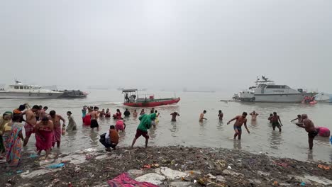 Toma-Cinematográfica-De-Hindúes-Bañándose-En-El-Río-Ganges-En-Babu-Ghat,-Kolkata,-Para-La-Celebración-Del-Festival-Sankranti