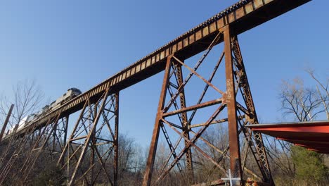 Two-Norfolk-Southern-Engines-Lead-an-Intermodal-Train-across-the-Pope-Lick-Trestle-in-Louisville,-KY-during-Golden-Hour