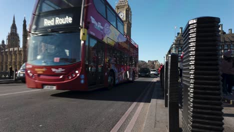 Taxis-Negros-Y-Autobuses-Rojos-De-Dos-Pisos-Conduciendo-Sobre-El-Puente-De-Westminster-Con-El-Big-Ben-Al-Fondo-En-Un-Día-Soleado-De-Enero