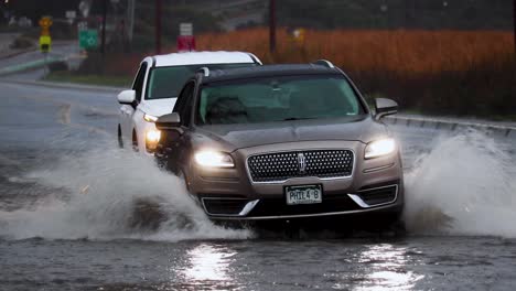 Driving-American-on-flooded-road-with-splashing-water