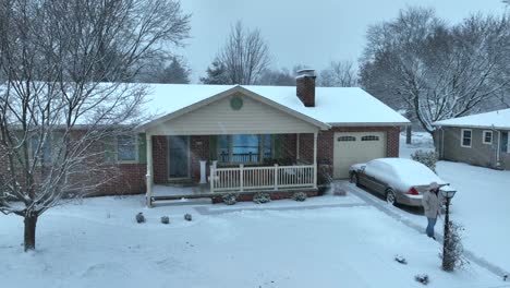 Person-walking-on-shoveled-driveway-during-snow-storm